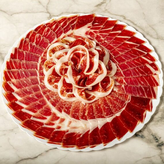 Plato de jamón ibérico con las lonchas dispuestas en una presentación floral